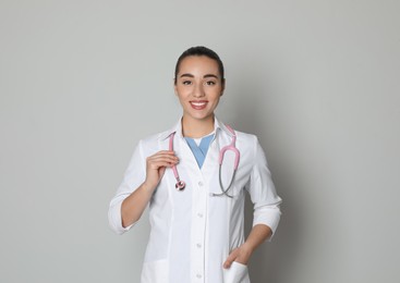 Photo of Portrait of beautiful young doctor on light grey background