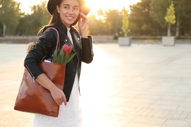 Woman with leather shopper bag on city street