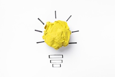 Photo of Idea concept. Light bulb made with crumpled paper and drawing on white background, top view