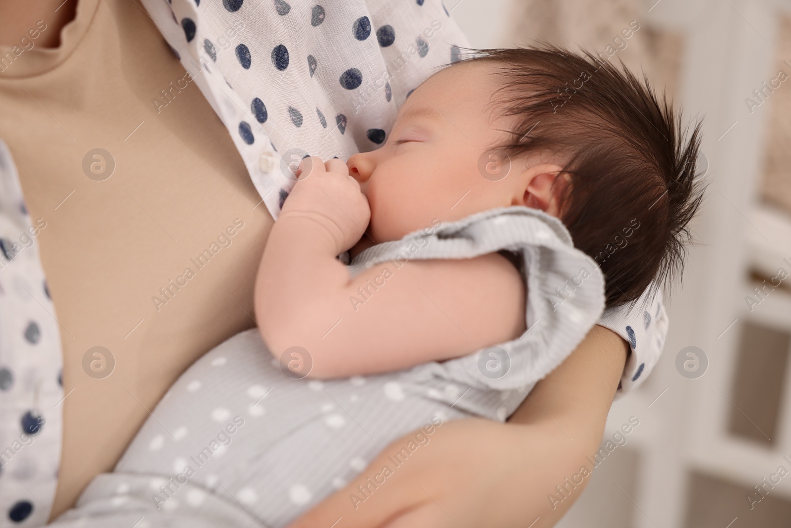 Photo of Mother with her sleeping newborn baby indoors, closeup