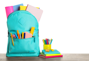 Photo of Bright backpack with school stationery on wooden table against white background