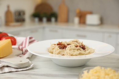 Photo of Delicious pasta with grated cheese on white marble table in kitchen, closeup