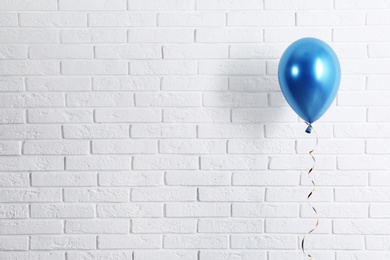 Photo of Bright balloon near brick wall, space for text. Party time