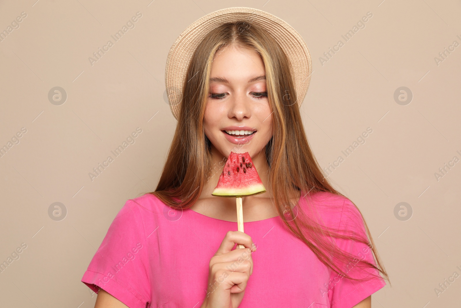 Photo of Beautiful girl with pieces of watermelon on beige background