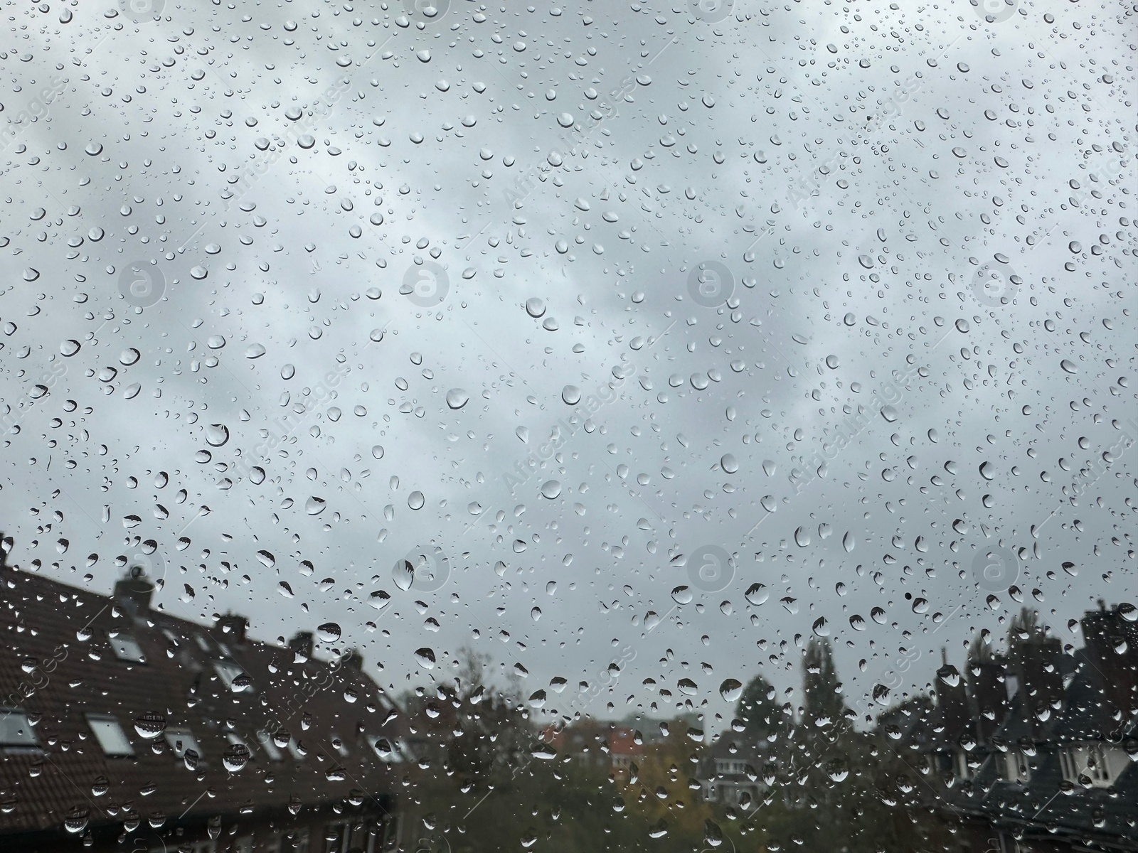 Photo of Window with water droplets on rainy day, closeup