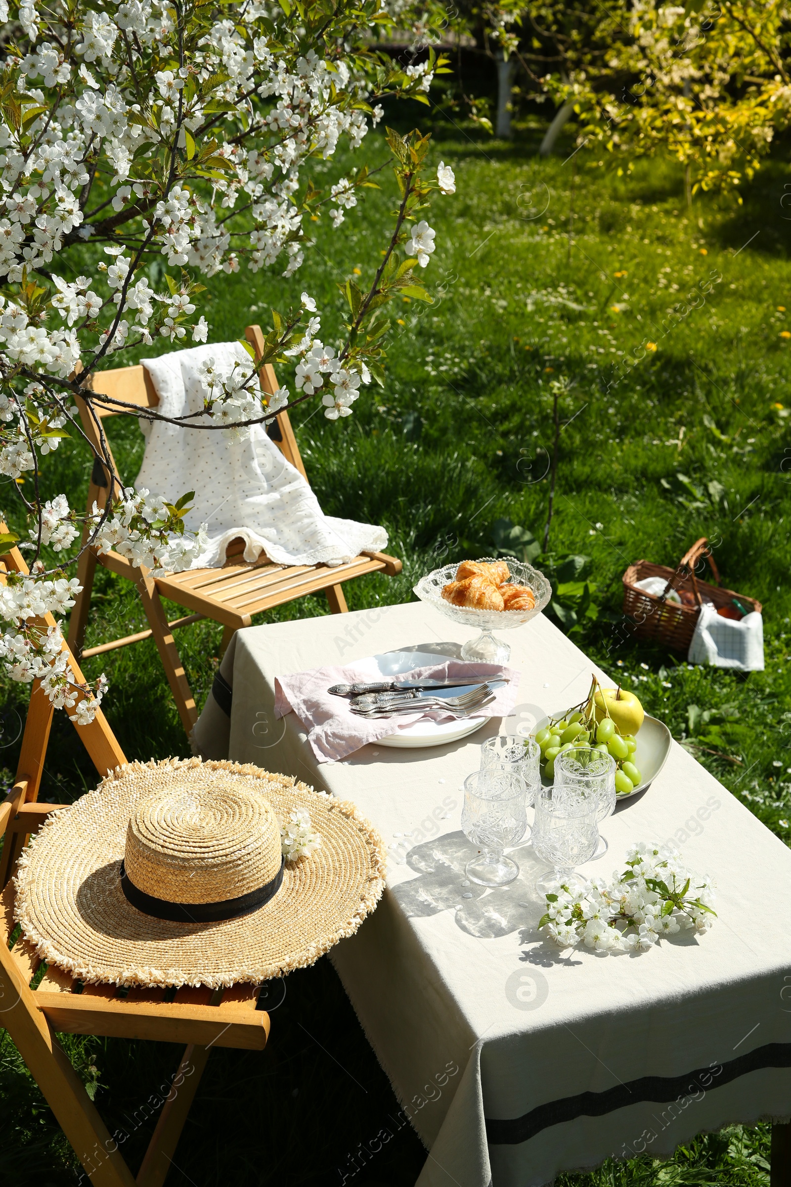 Photo of Stylish table setting with beautiful spring flowers in garden on sunny day