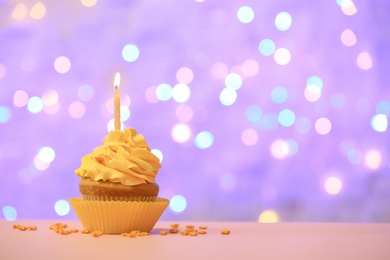 Photo of Birthday cupcake with candle against blurred lights