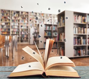 Open book with letters flying out of it in library