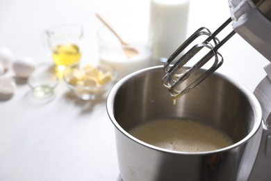 Photo of Making dough in bowl of stand mixer on white table. Space for text