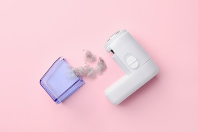 Photo of Fabric shaver with fuzz on pink background, flat lay