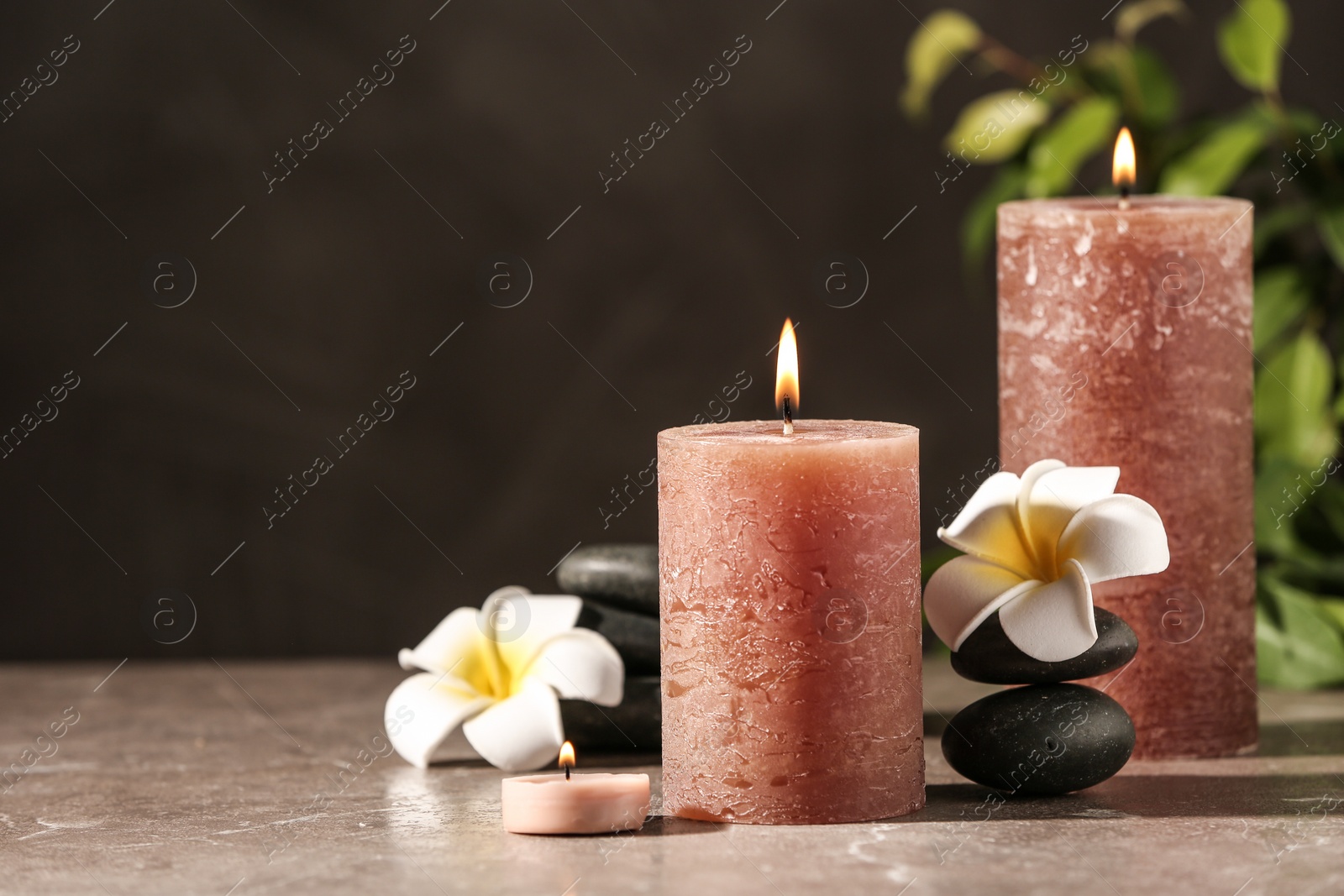 Photo of Composition with candles and spa stones on marble table. Space for text