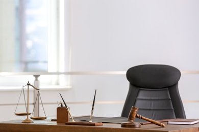 Photo of Table with scales of justice and judge gavel in lawyer's office