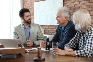 Male notary working with mature couple in office