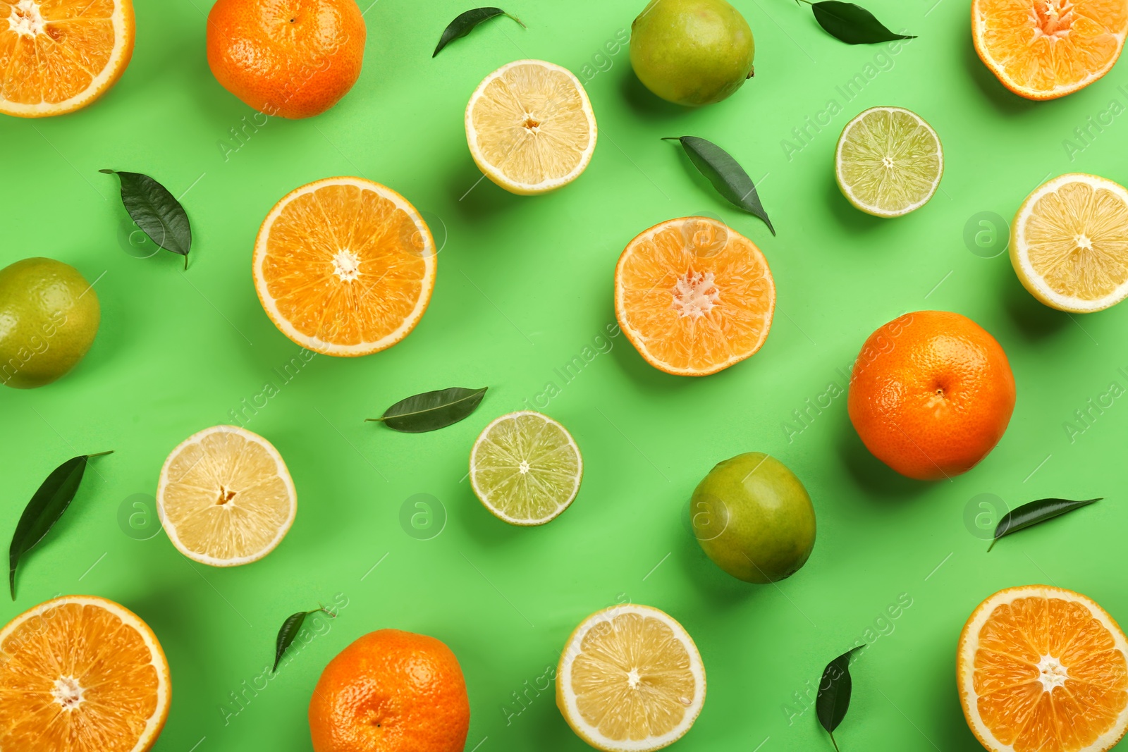 Photo of Flat lay composition with tangerines and different citrus fruits on green background