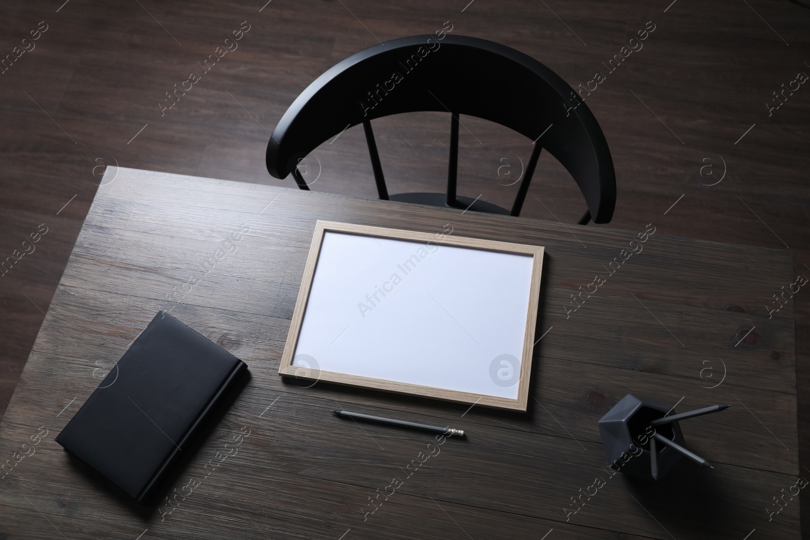 Photo of Modern wooden table with stationery and chair indoors