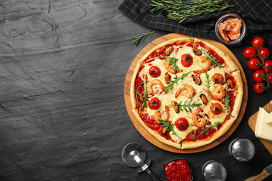 Photo of Delicious seafood pizza on black table, flat lay. Space for text