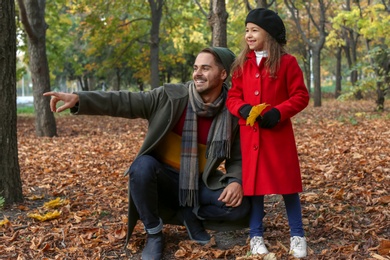 Photo of Father and his cute daughter spending time together in park. Autumn walk