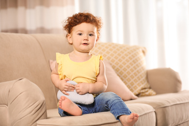 Photo of Portrait of cute little child on sofa at home