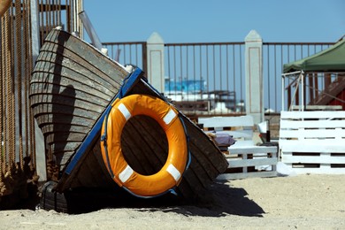 Photo of Orange lifebuoy hanging on wooden boat outdoors