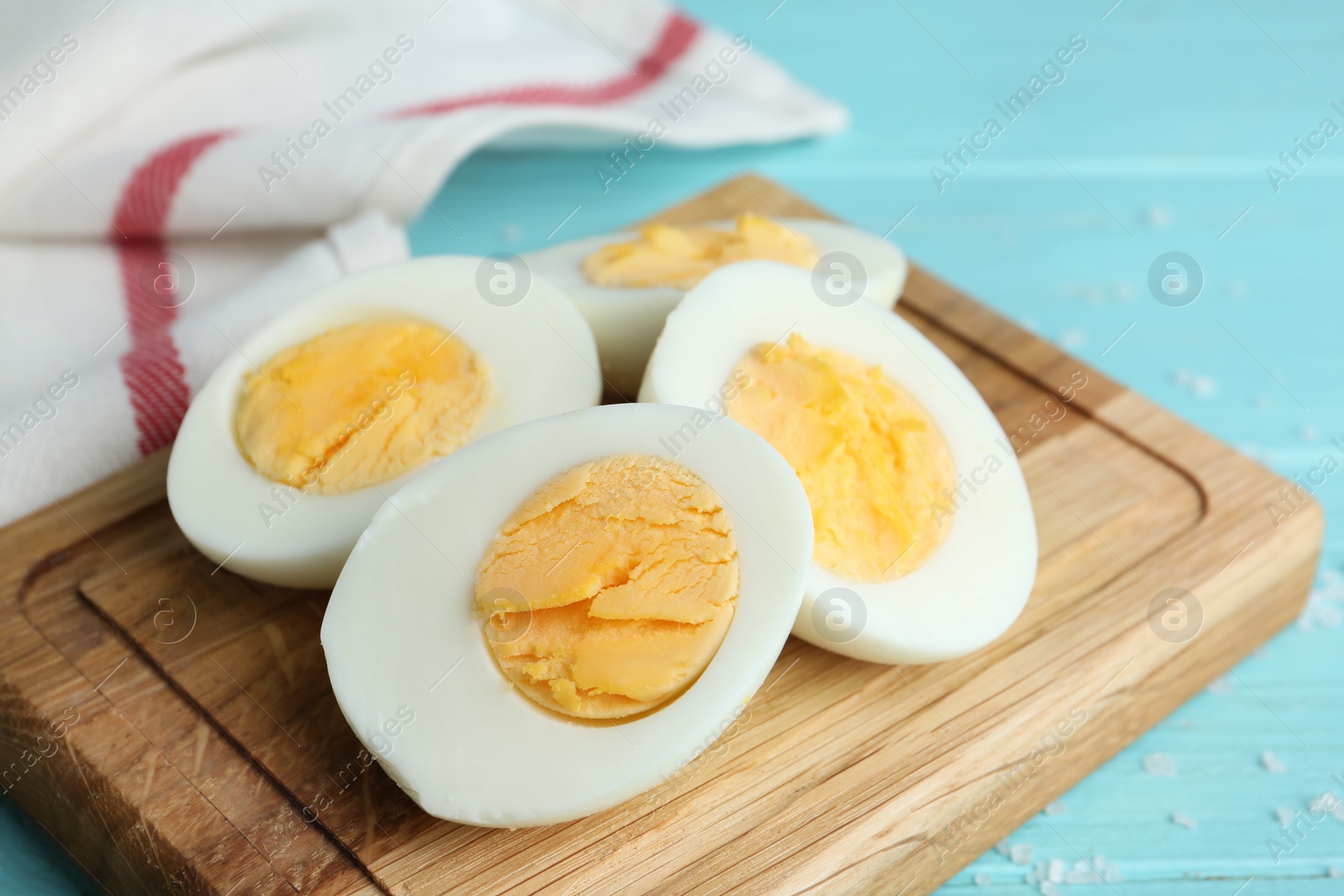 Photo of Cut hard boiled chicken eggs on wooden board