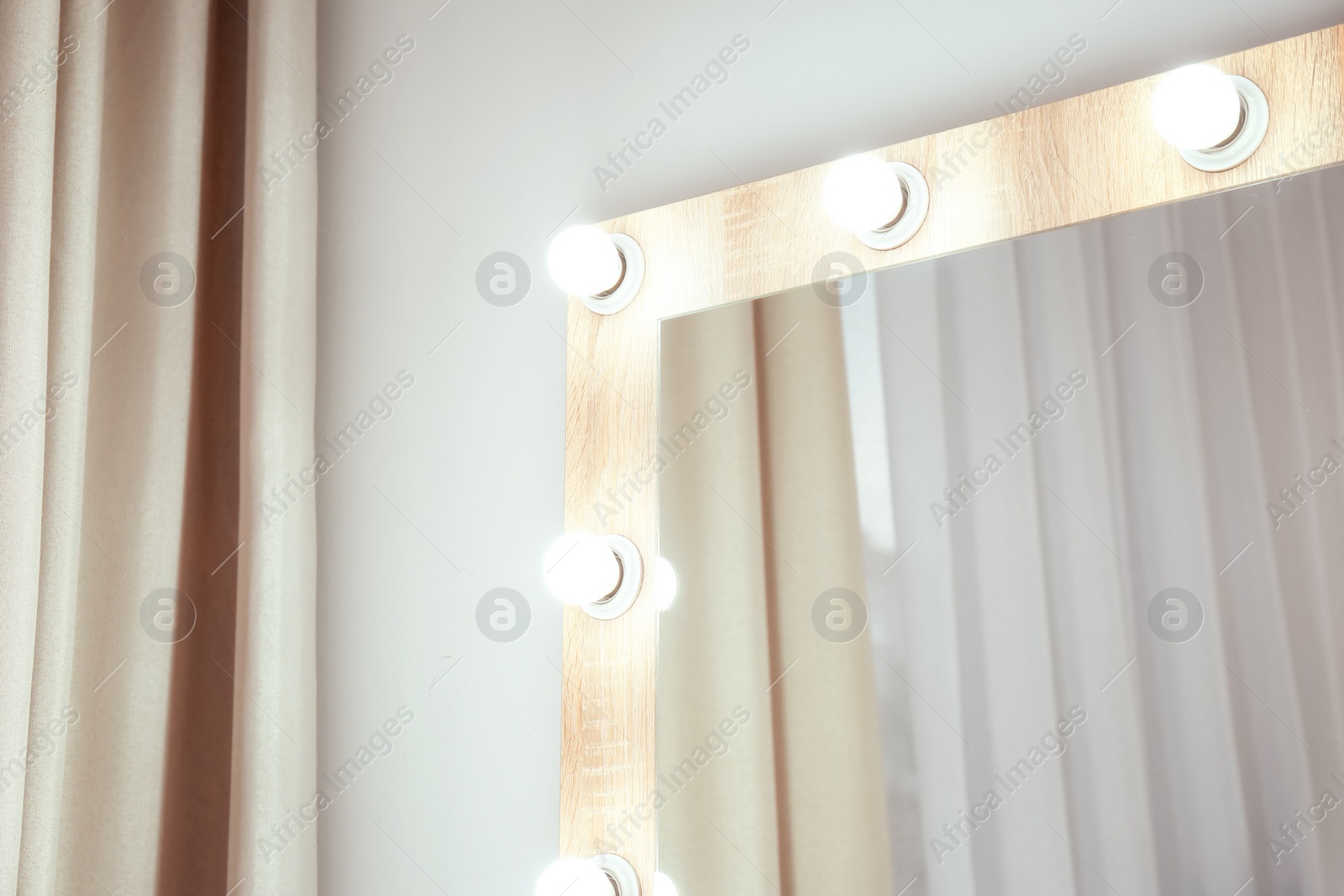 Photo of Makeup mirror near white wall in dressing room. Space for text