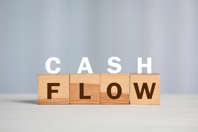 Image of Phrase Cash Flow made with letters and wooden cubes on light background