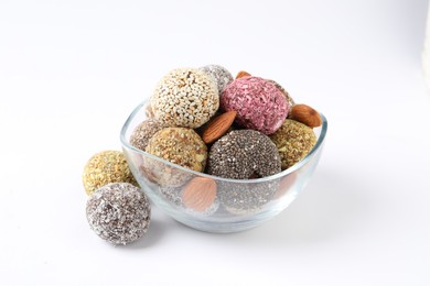 Photo of Different delicious vegan candy balls with almonds on white background