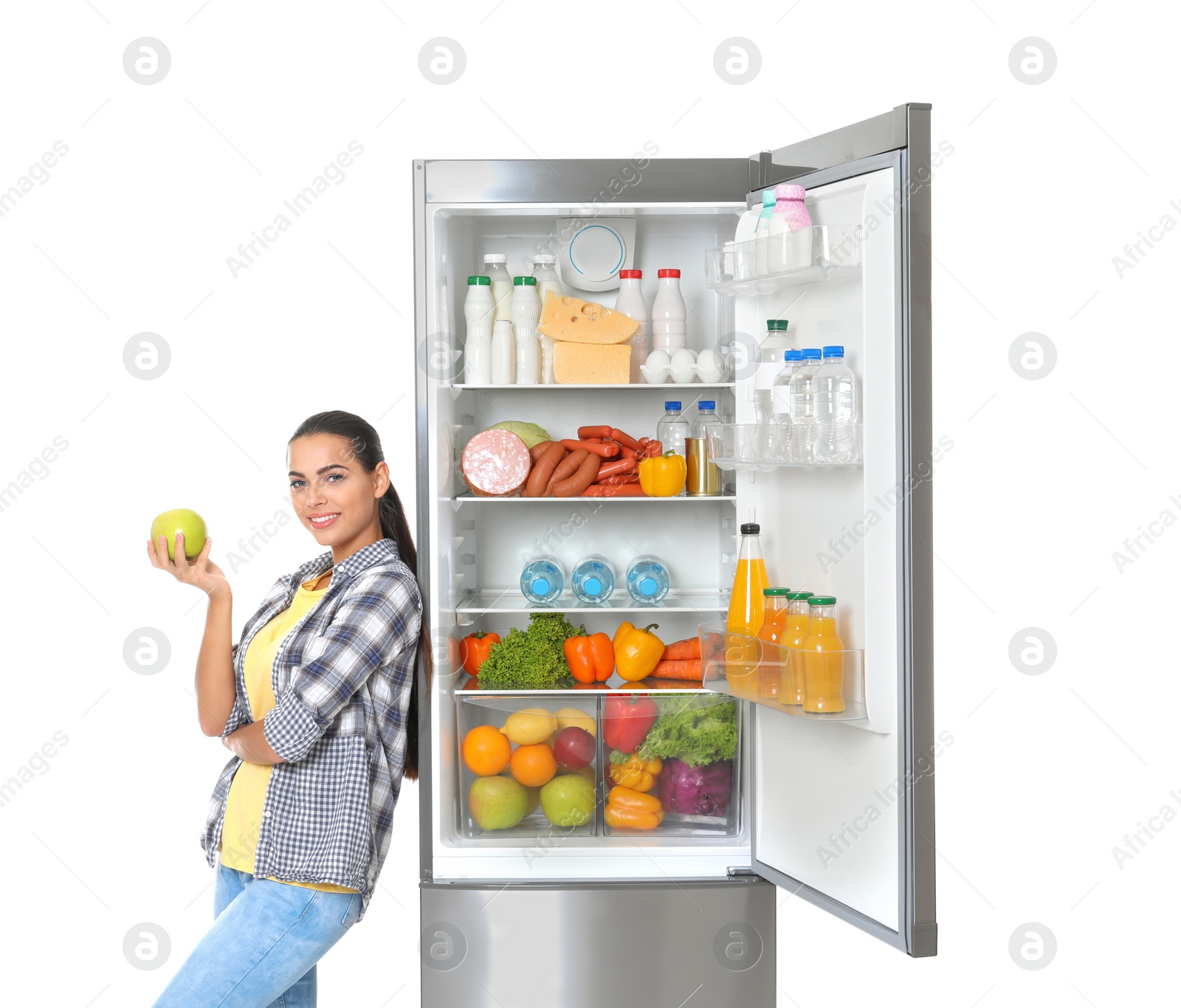 Photo of Young woman with apple near open refrigerator on white background