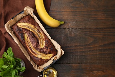 Delicious banana bread and ingredients on wooden table, flat lay. Space for text