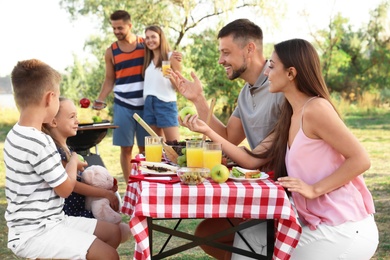 Happy families with little children having picnic in park