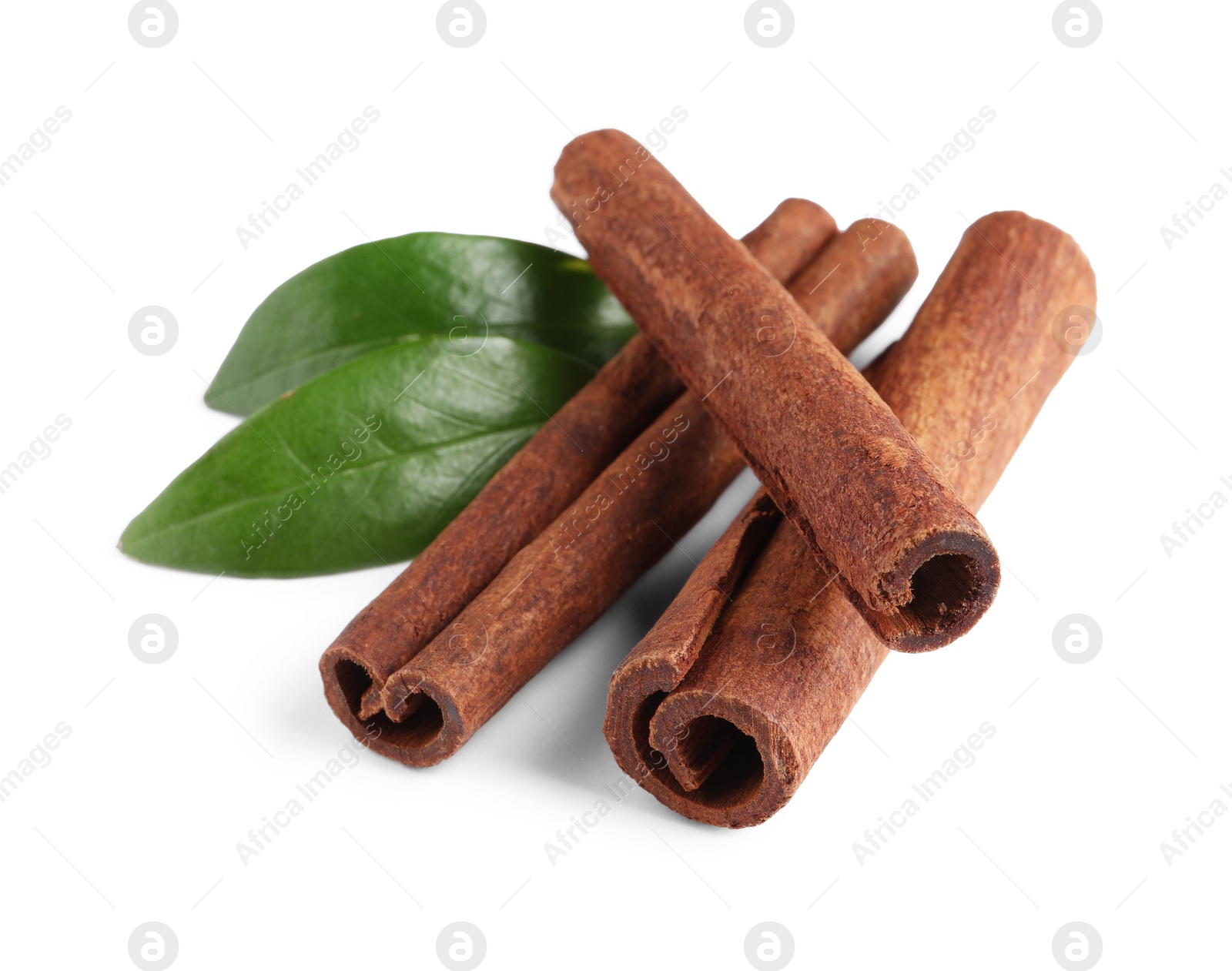 Photo of Cinnamon sticks and green leaves isolated on white