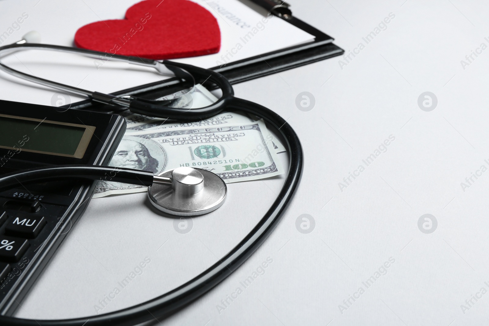 Photo of Stethoscope with money and calculator on white background. Health insurance concept