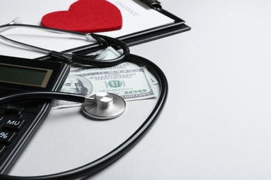 Photo of Stethoscope with money and calculator on white background. Health insurance concept