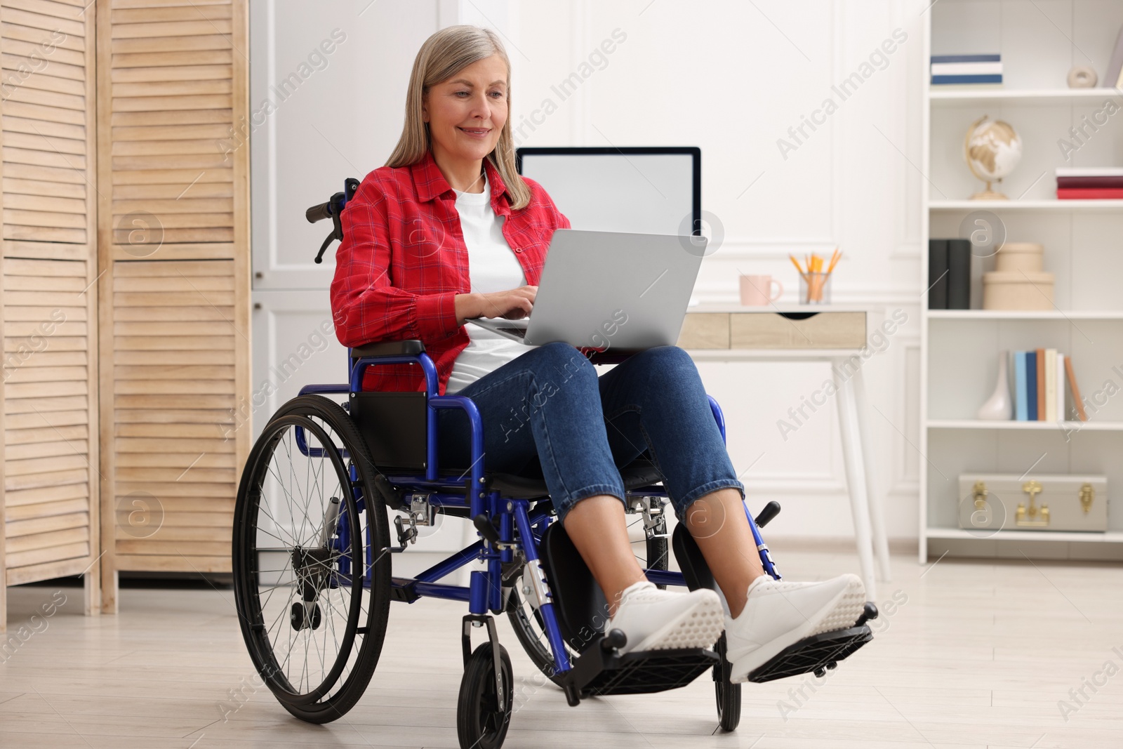 Photo of Woman in wheelchair using laptop at home