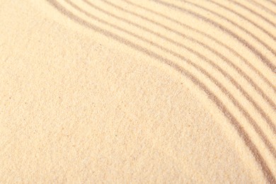 Photo of Zen rock garden. Wave pattern on beige sand