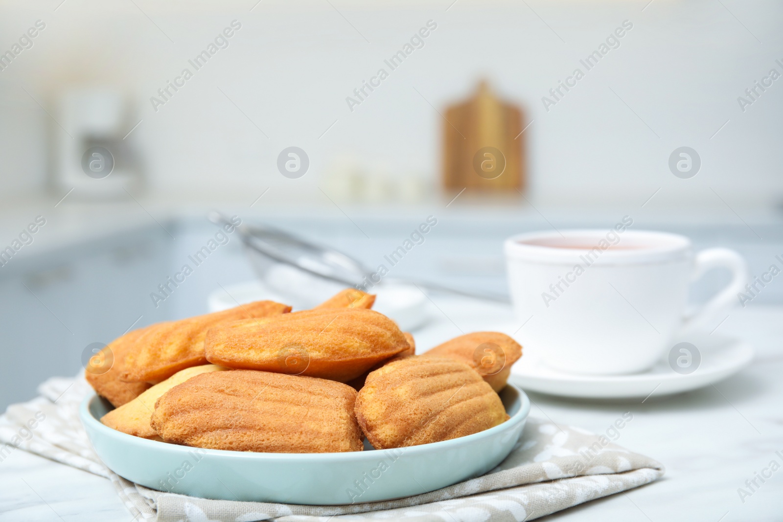 Photo of Tasty madeleine cookies on table in kitchen