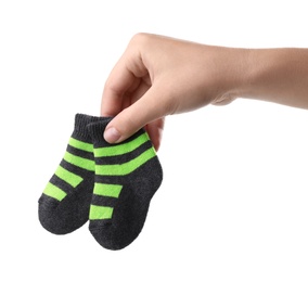 Woman holding pair of cute child socks on white background, closeup