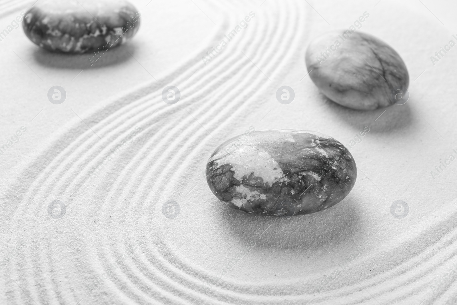 Photo of Stones on sand with pattern. Zen concept