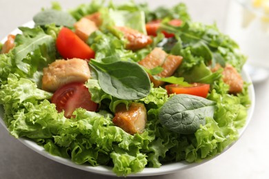 Photo of Delicious salad with chicken, cherry tomato and spinach on table, closeup