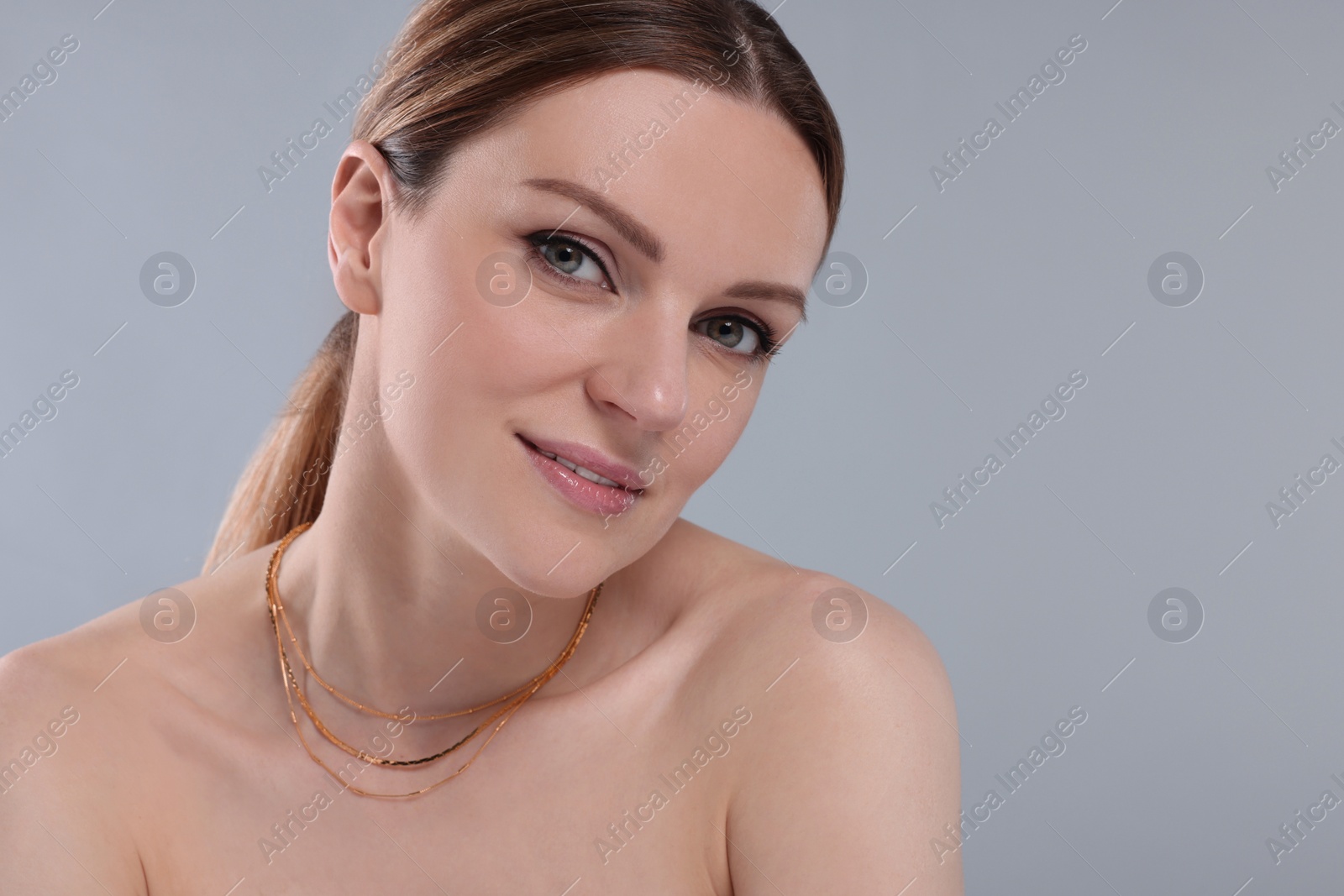 Photo of Beautiful woman with elegant necklace on light grey background. Space for text