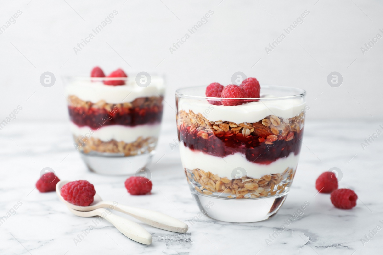 Photo of Delicious oatmeal dessert with raspberries in glasses on table