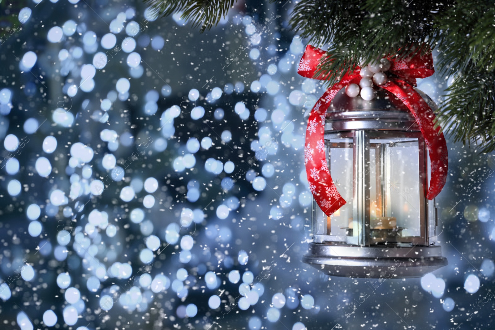 Image of Vintage Christmas lantern with burning candle hanging on fir branch against color background, bokeh effect. Space for text