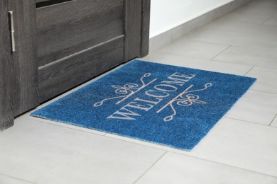 Photo of Beautiful doormat with word Welcome on floor near entrance