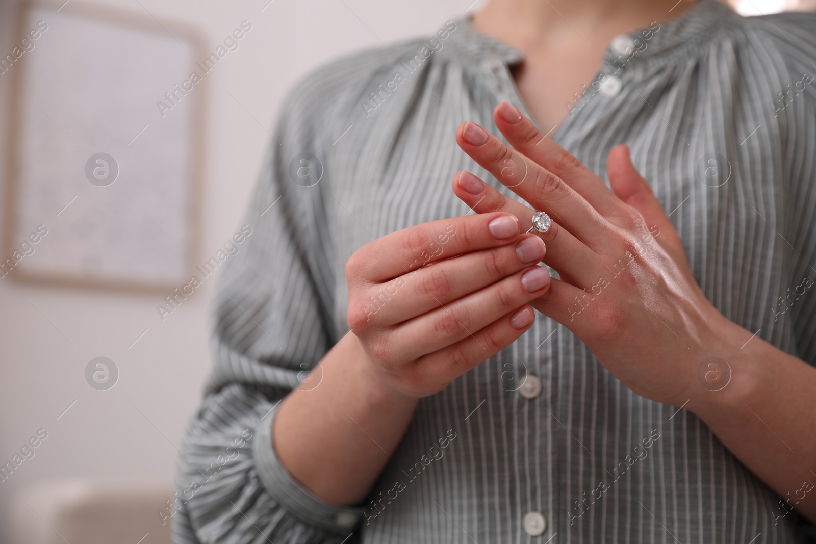 Photo of Woman taking off wedding ring indoors, closeup with space for text. Divorce concept