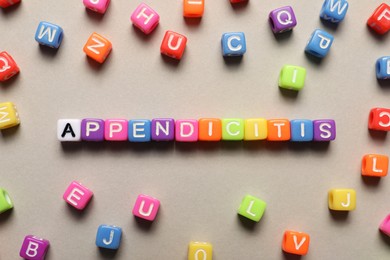 Photo of Word Appendicitis made of color cubes with letters on light background, flat lay