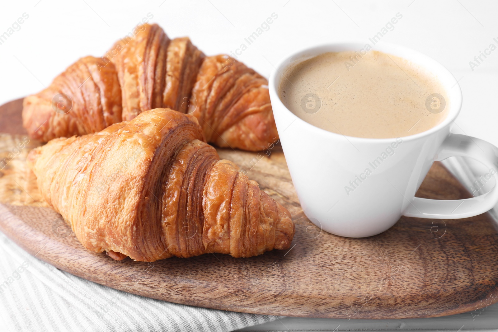 Photo of Tasty breakfast. Cup of coffee and croissants on table, closeup