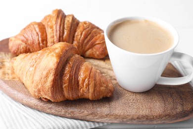 Tasty breakfast. Cup of coffee and croissants on table, closeup