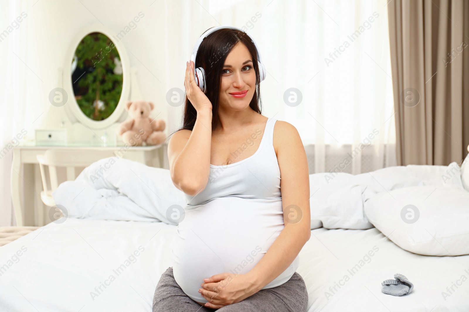 Photo of Beautiful pregnant woman listening to music at home