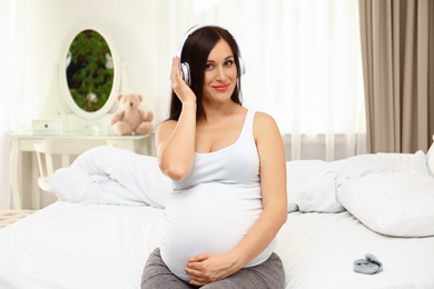 Photo of Beautiful pregnant woman listening to music at home