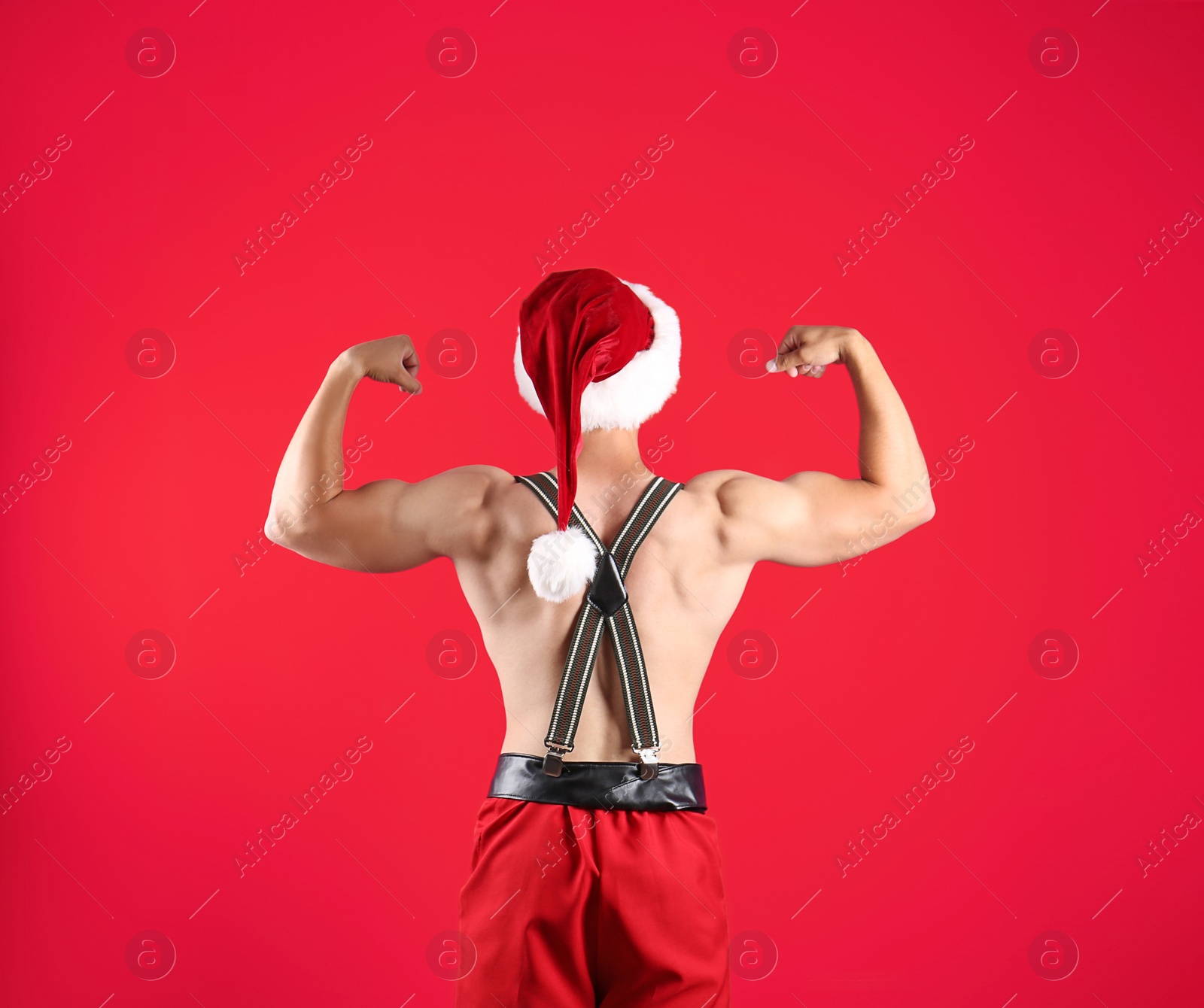 Photo of Shirtless young Santa Claus with sexy body on color background